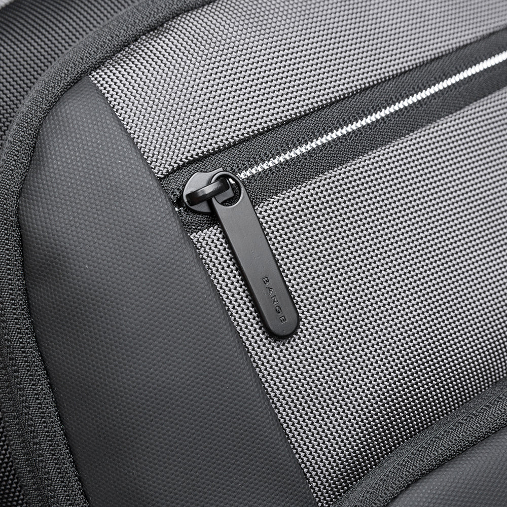 Detalle del cierre frontal de la mochila Bange The Classic en color gris, con tirador de goma personalizado.