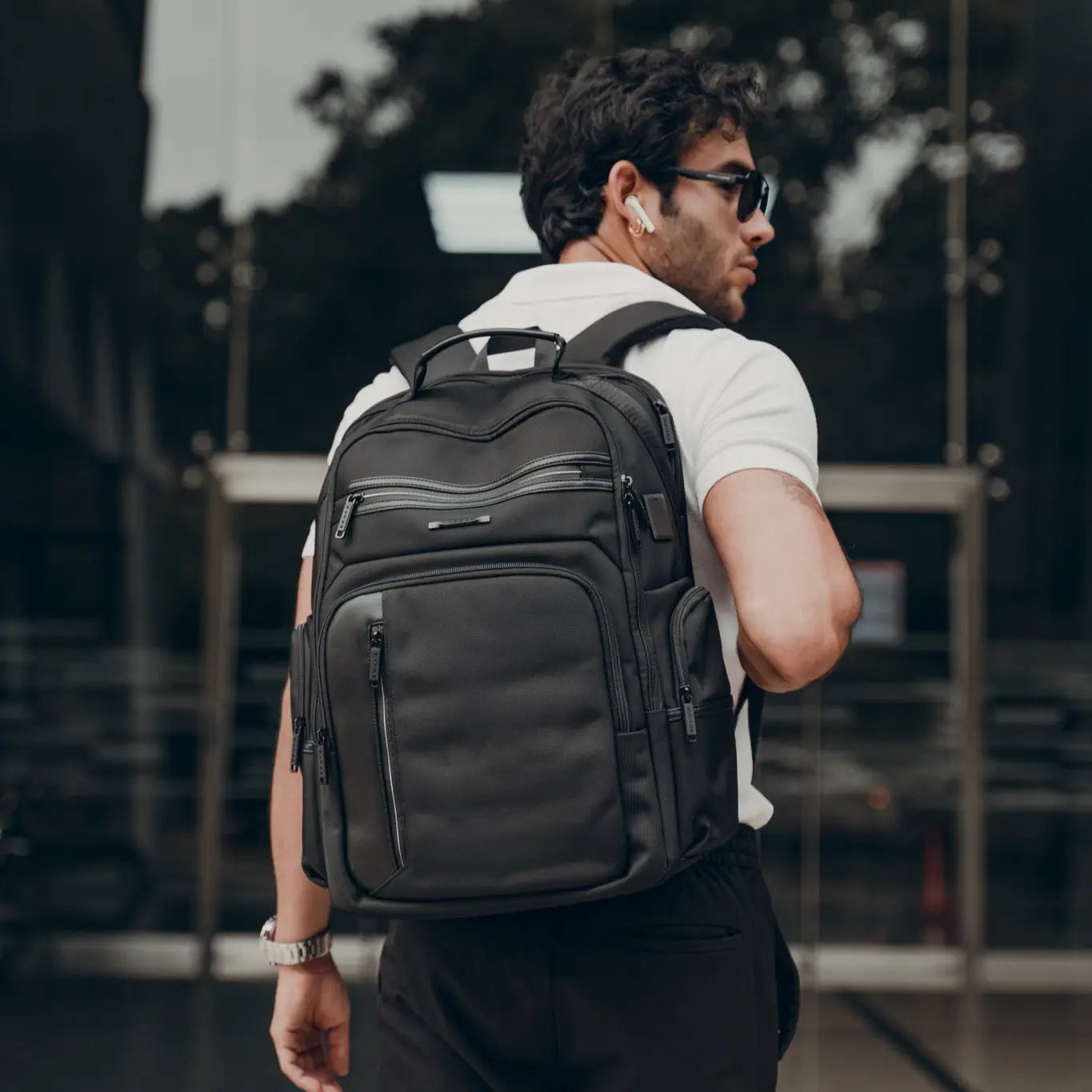 Hombre usando la mochila The Blackpack de Bange en un entorno urbano, ideal para trabajo o viajes.
