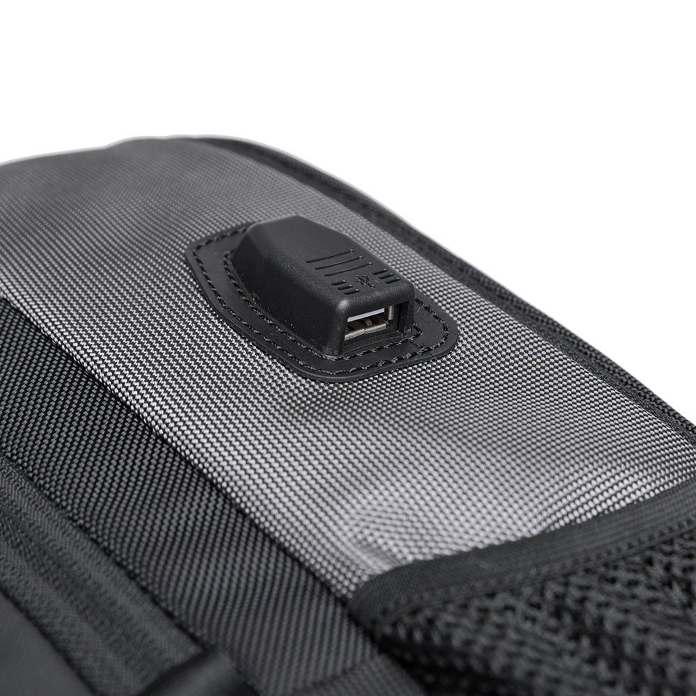 Detalle del puerto USB externo de la mochila The Classic de Bange en color gris, ideal para cargar dispositivos móviles durante los desplazamientos.

