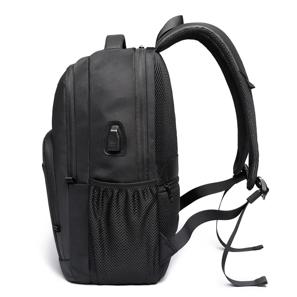 Vista lateral de la mochila The Classic de Bange en color negro, mostrando su puerto USB integrado, bolsillo elástico y tirantes ergonómicos.

