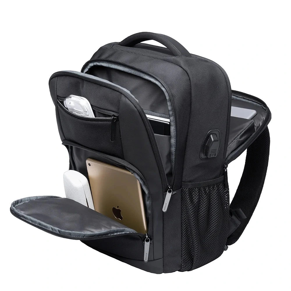 Vista frontal de la mochila The Classic de Bange completamente abierta, mostrando su interior organizado con compartimentos para laptop, tablet y accesorios, incluyendo puerto USB lateral.

