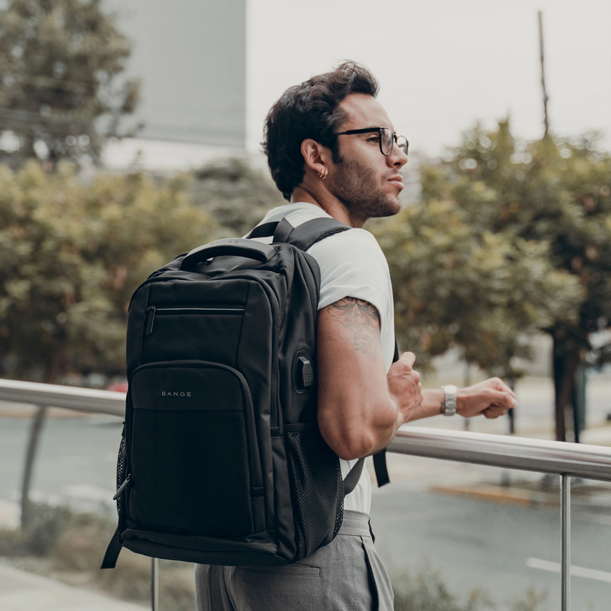 Hombre moderno usando la mochila The Classic de Bange en un entorno urbano, destacando su estilo ejecutivo y funcional para el día a día.

