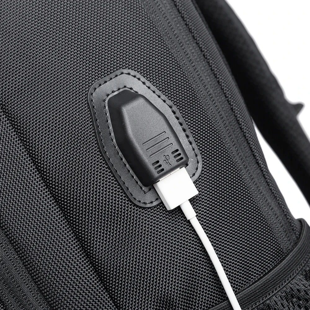 Detalle del puerto de carga USB externo en la mochila The Classic de Bange, ideal para cargar dispositivos móviles en movimiento.