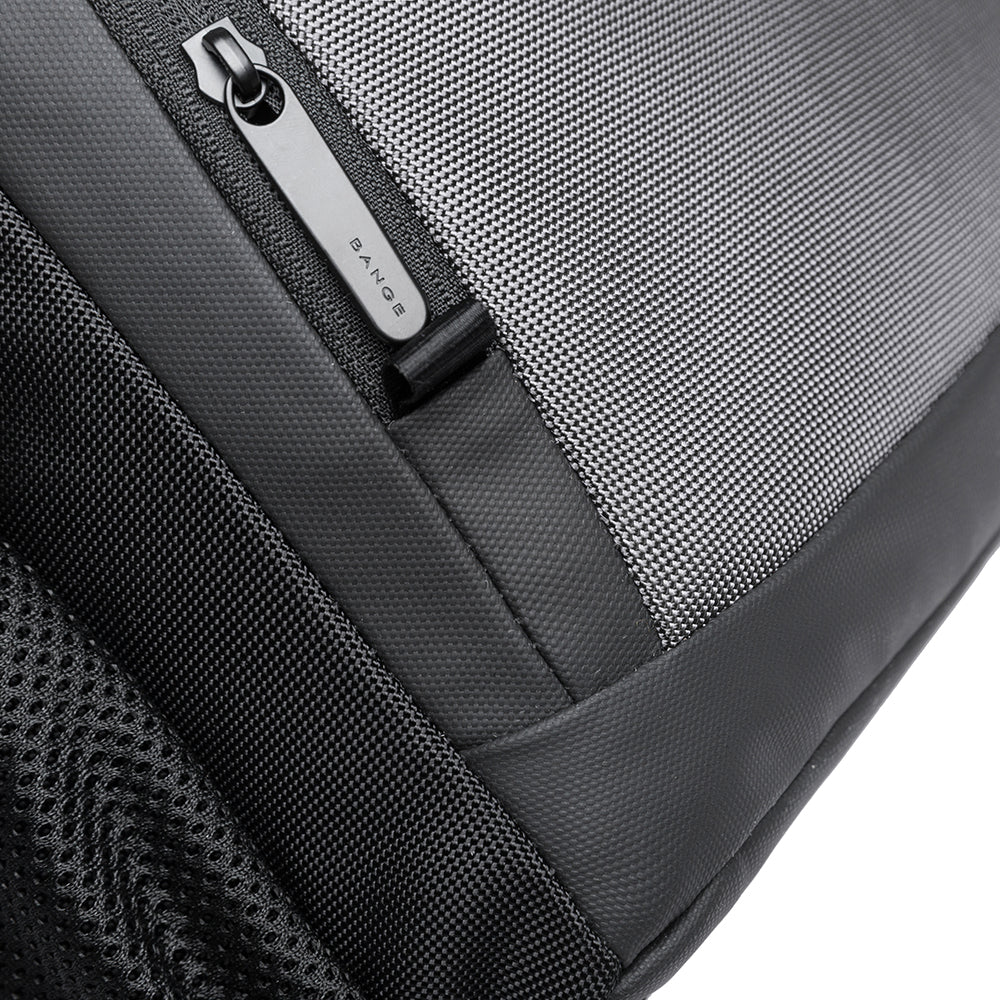 Detalle del cierre lateral inferior de la mochila Bange The Classic en color gris, con tirador personalizado.

